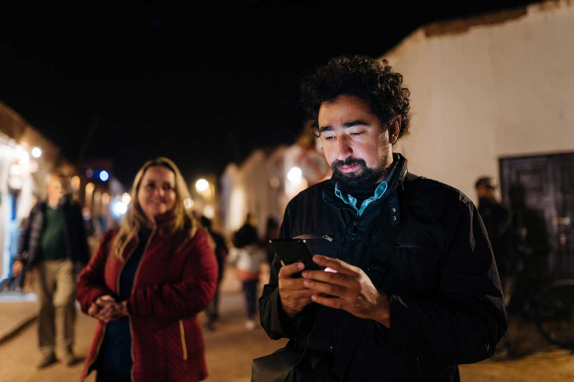 Man looking at his phone while out with friends